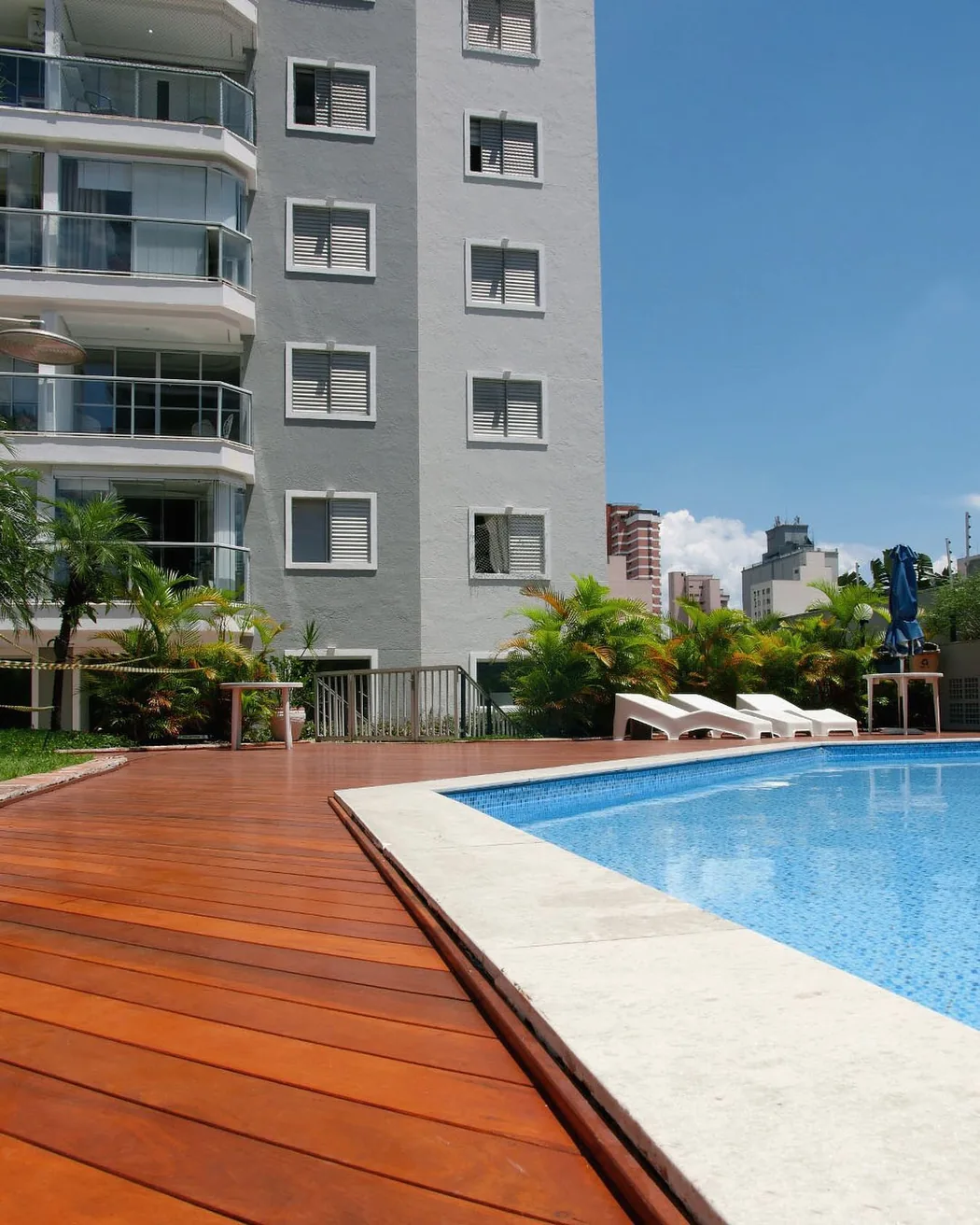 Deck de madeira em área de piscina de condomínio